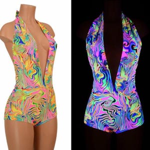 May include: A sleeveless bodysuit featuring a deep V-neckline and a halter-style neck strap. The garment displays a vibrant, multi-colored marbled pattern in neon pink, yellow, green, and blue hues, shown in both daylight and a glowing dark environment.