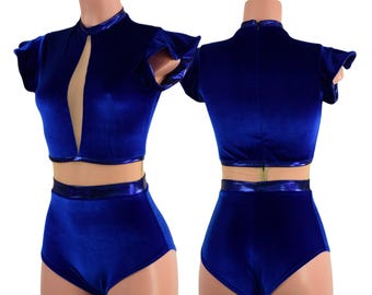 May include: A royal blue velvet crop top and high waisted shorts set with a keyhole neckline and ruffle sleeves. The set features a shiny silver trim.