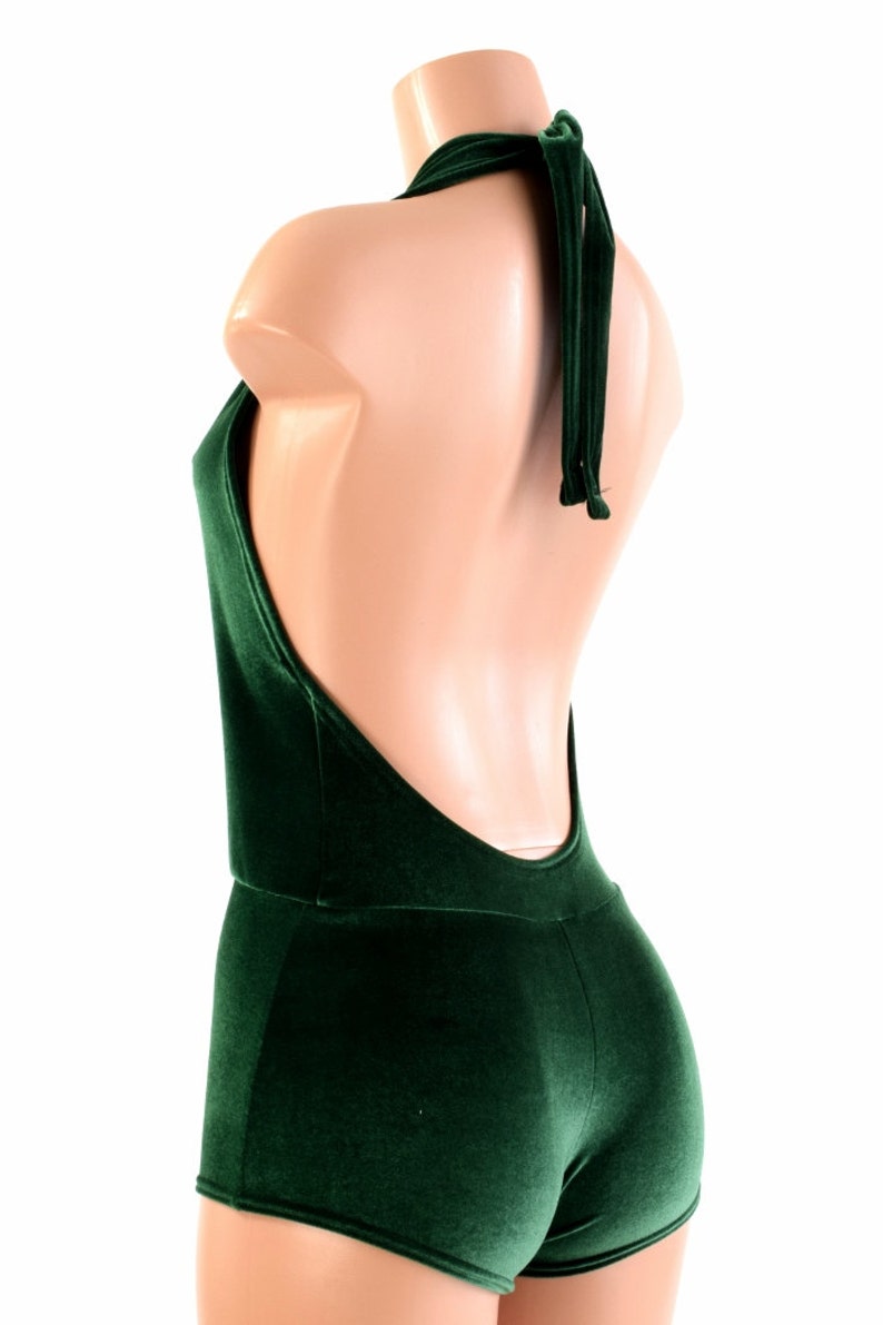 May include: A dark green velvet halter top with a low back and short shorts. The top has a tie at the back of the neck.