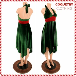 May include: A green velvet halter dress with a red sash. The dress has a high-low hemline and is fitted through the bodice. The dress is on a mannequin.