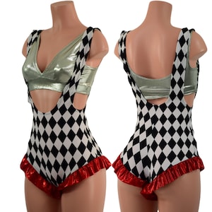 May include: Black and white diamond patterned romper with red ruffled trim. The romper has a scoop neck and adjustable straps. It is worn over a silver metallic tank top.