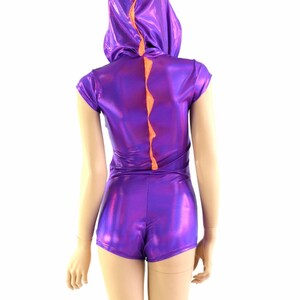 May include: Purple and orange shiny bodysuit with a short sleeve and a hood. The bodysuit has a tail that looks like a dinosaur spine.