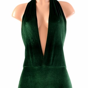 May include: A deep green velvet halter top with a plunging neckline and a short, fitted silhouette.