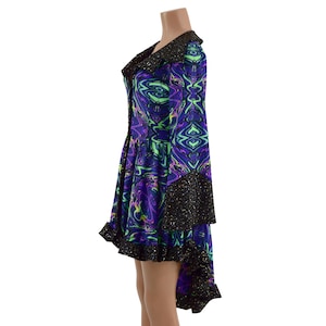 May include: A black and purple dress with a swirling pattern and a high-low hemline. The dress has long sleeves with a black glitter trim and a ruffled hem.