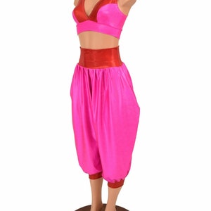 May include: A pink and red two-piece outfit with a halter top and harem pants. The top has a red band around the bust and the pants have a red band at the waist and the bottom of the legs.