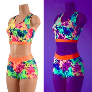 May include: A two-piece athletic outfit with a tie-dye pattern in shades of pink, blue, green, and yellow. The top and shorts have a bright orange trim.