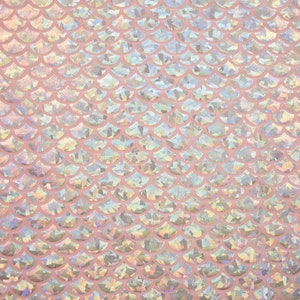 Pu&ograve; includere: Tessuto rosa iridescente con un motivo a squame di sirena.