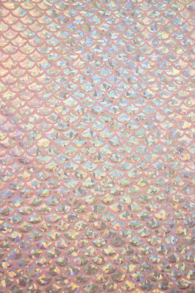Pu&ograve; includere: Tessuto rosa iridescente con un motivo a squame di sirena.