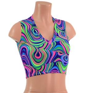 May include: A sleeveless crop top featuring a vibrant, multi-colored psychedelic swirl pattern in neon pink, bright green, and royal blue. The garment has a V-neckline and a fitted silhouette, showcasing a continuous abstract wavy design throughout.