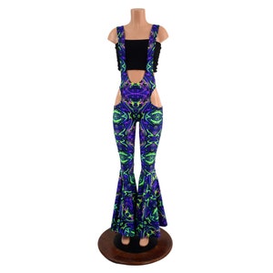 May include: A pair of black and purple bell bottom pants with a psychedelic swirl pattern. The pants have cutouts on the sides and are worn with a black crop top.