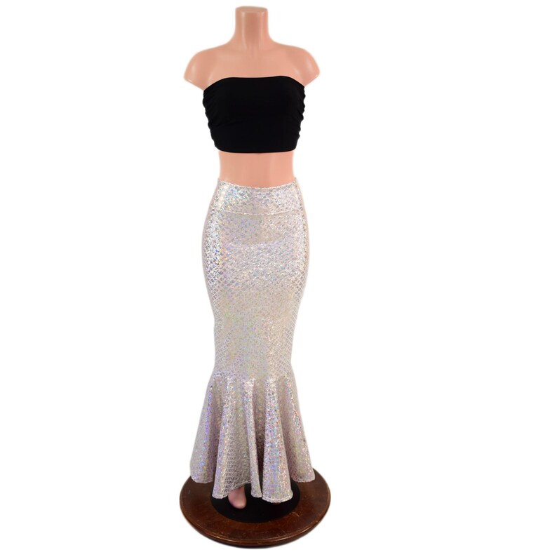 May include: A two-piece outfit consisting of a black strapless tube top and a floor-length, high-waisted mermaid skirt. The skirt features a shimmering, iridescent, scale-like pattern that reflects light with a metallic, silver-toned finish.