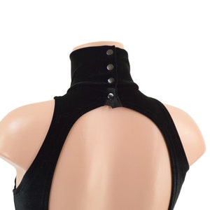 Op de afbeelding: Zwarte fluwelen turtleneck met een sleutelgatrug en knoopsluitingen aan de achterkant van de nek.