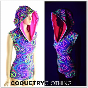May include: A neon green, pink, and blue swirl print hooded bodysuit with a pink lining. The bodysuit has short sleeves and a scoop neck. The hood is lined with pink fabric. The image shows the bodysuit in both regular and blacklight conditions.