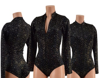 May include: Black bodysuit with long sleeves and a high collar. The fabric is covered in small, shimmering gold and silver flecks. The bodysuit has a zipper that extends from the collar to the mid-chest. The garment is displayed on a mannequin.