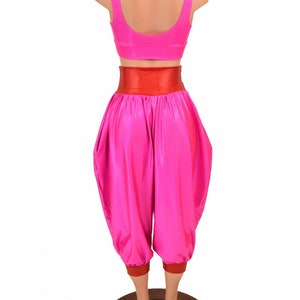 May include: A pink and red dance costume with a high-waisted, wide-legged pant and a cropped top. The pants have a red waistband and red trim at the bottom.