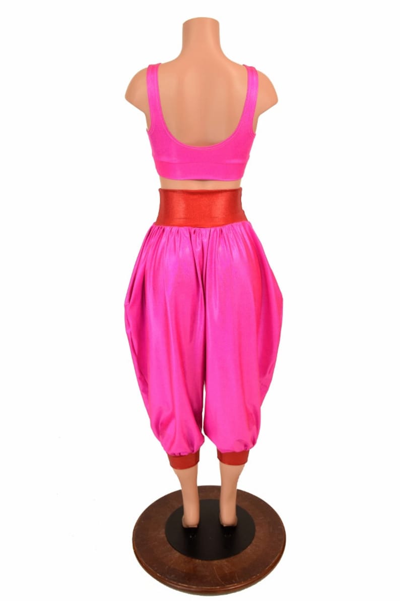 May include: A pink and red dance costume with a high-waisted, wide-legged pant and a cropped top. The pants have a red waistband and red trim at the bottom.