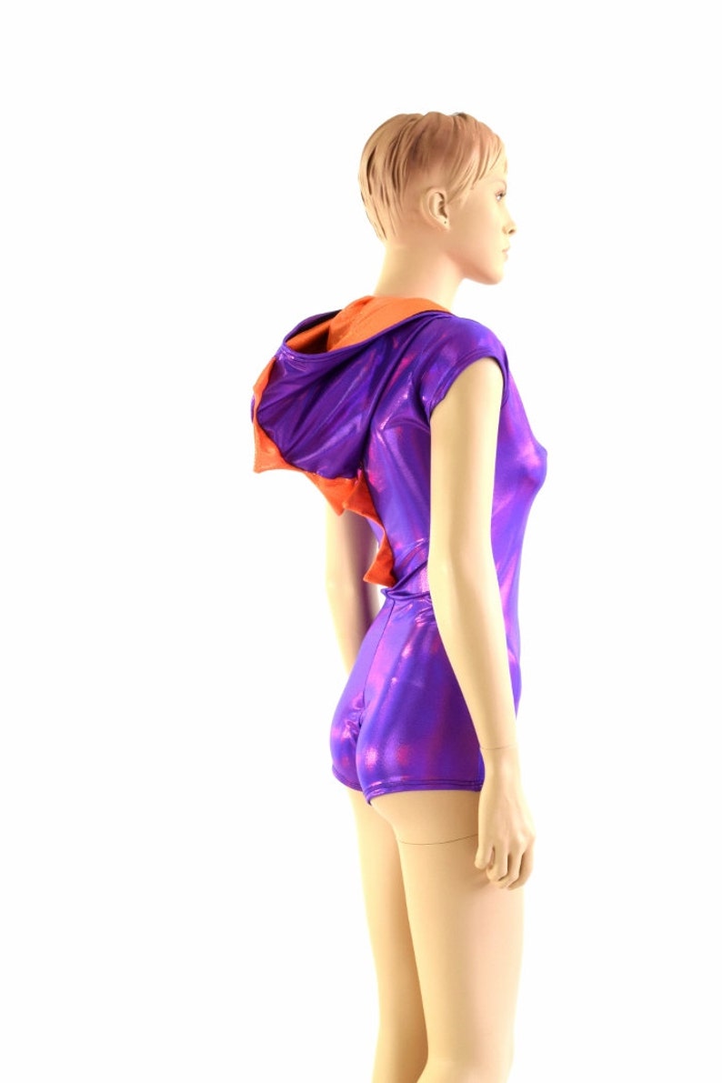 May include: A purple and orange hooded leotard with a shiny, iridescent finish. The leotard has short sleeves and a fitted silhouette.