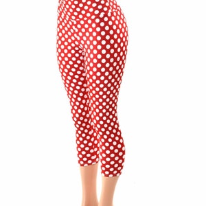 May include: Red and white polka dot leggings with a high waist. The leggings are cropped and end just below the knee.