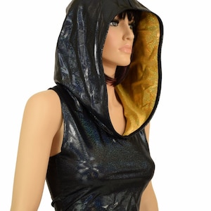 May include: A black sleeveless crop top with a gold lining on the hood. The top is made of a shiny, iridescent fabric.