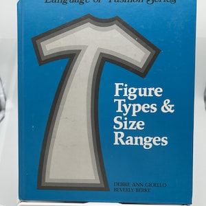 May include: A blue book titled "Language of Fashion Series" with the text "Figure Types & Size Ranges." The cover features a stylized illustration of a t-shirt shape in shades of gray. Authors are Debbie Ann Gioello and Beverly Berke.