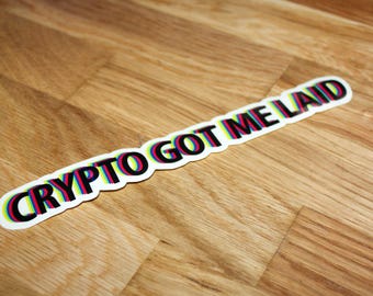 May include: A white sticker with the text "CRYPTO GOT ME LAID" in black letters with a rainbow effect.