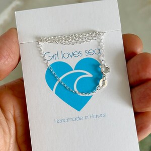 May include: A silver chain necklace with a lobster clasp. The necklace is on a white card with the text "Girl loves sea" and "Handmade in Hawaii".