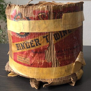 May include: A vintage cardboard spool of binder twine with a red and yellow label that reads "Binder Twine" and "Average Length 500 ft. Average Strength 110 lbs."