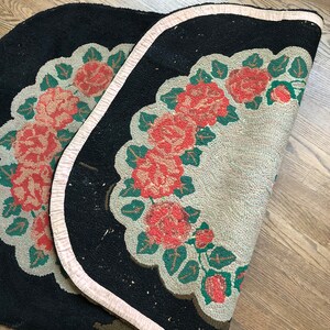 Puede incluir: Una alfombra negra y blanca con un borde rosa. La alfombra tiene un dise&ntilde;o floral con rosas rojas y hojas verdes.