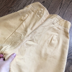 Op de afbeelding: Een lichtgele broek met een achterzak en een knoopsluiting. De broek is gemaakt van een zachte, comfortabele stof.