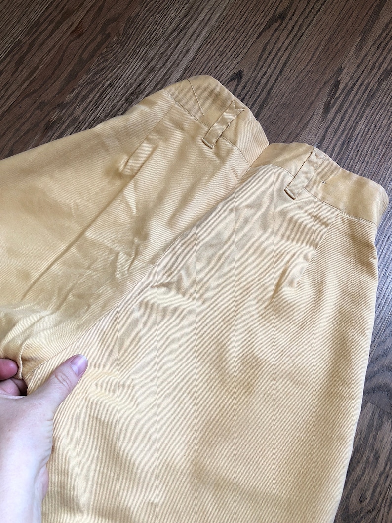 Op de afbeelding: Een lichtgele broek met een achterzak en een knoopsluiting. De broek is gemaakt van een zachte, comfortabele stof.