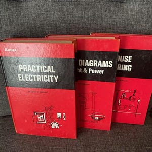 May include: Three vintage books with red covers and black bands. The titles include "Practical Electricity", "Diagrams Light & Power", and "House Wiring". Each book has white text and illustrations.