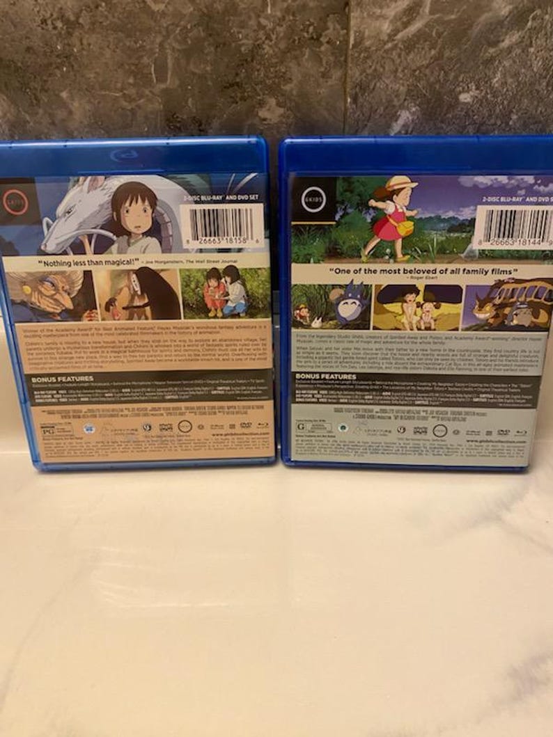 May include: Two blue Blu-ray and DVD sets. One features a girl and a dragon with the text "Nothing less than magical!". The other shows a girl in a field with the text "One of the most beloved of all family films".