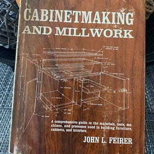 May include: A vintage book titled "Cabinetmaking and Millwork" with a brown cover. The cover features a detailed diagram of cabinet construction and the author's name, John L. Feirer. The book is a comprehensive guide to building furniture, cabinets, and interiors.