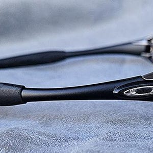 Peut inclure: Lunettes de soleil noires avec une finition mate. Les montures ont un design incurv&eacute; et &eacute;l&eacute;gant avec le logo de la marque sur les branches. Les verres sont sombres et les branches ont une prise textur&eacute;e.