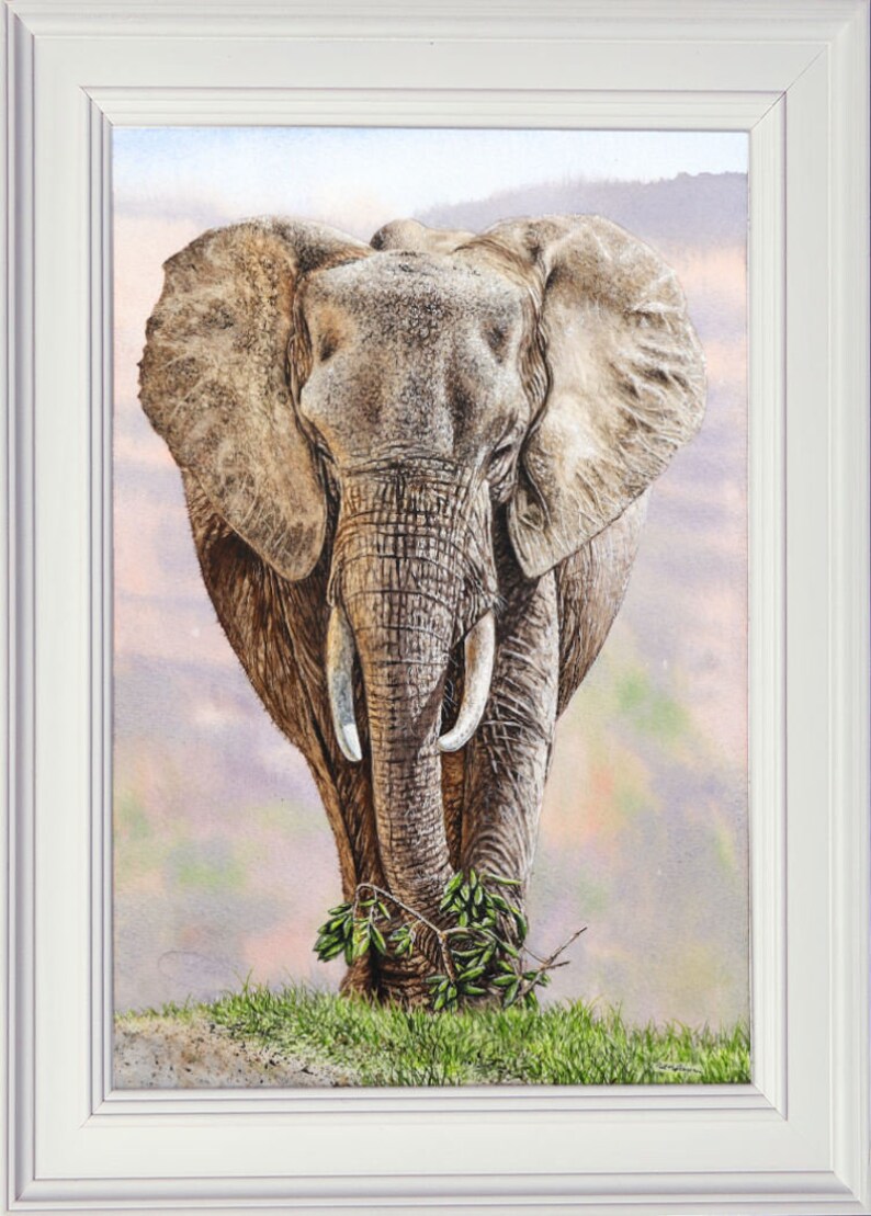 The finished elephant painting in a white frame.  This shows the animal walking forwards, set against pink mountains.  It is highly realistic and painted in tiny details.