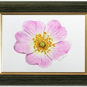 The original rose painting in a dark green frame with a gold trim on the inside edge.