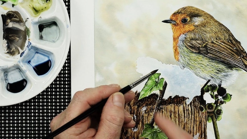 Paul is working with a pale blue wash, and is applying it over the snow.  His palette of watercolour paints is shown to the left.
