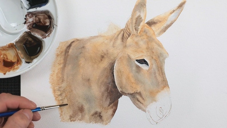 In this photo Paul is in the early stages of the painting. The eye looks complete, and he is just finishing off applying a base wash to the rest of the donkey.