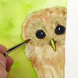 Both eyes are painted in this photo, and the beak is painted too.  Paul is just applying a brown foundation wash to the owl's head and body.