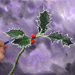 Paul's hand with a small brush in it is shown to the left, as he adds a white frosty edge to a sprig of holly he has painted in front of a purple background.  The leaves and berries are highly detailed and like an illustration.