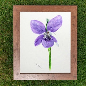 The original violet flower painting in a wooden frame, which is laid on a lawn