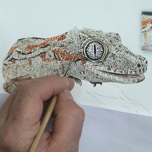 The lizard is almost finished in this photo, Paul is working in the fine details that are in orange and form lines along the length of the body.