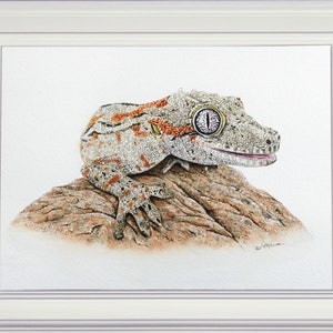 The finished painting of the gecko shown in a white frame.