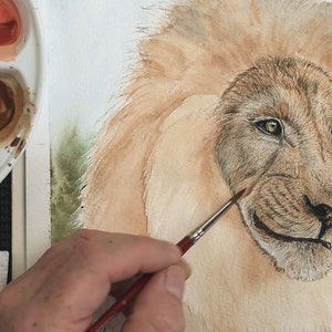 The wash is complete in this photo, and Paul is working with duller brown colours to apply the fur to the face.  This is surrounded by a huge mane, but this is yet to have detail added to it.
