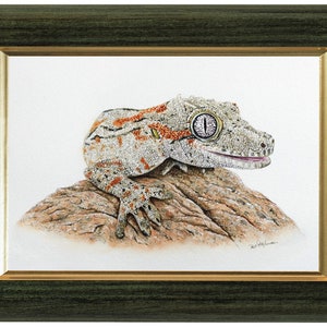 The gecko painting shown in a green frame with a gold internal border.