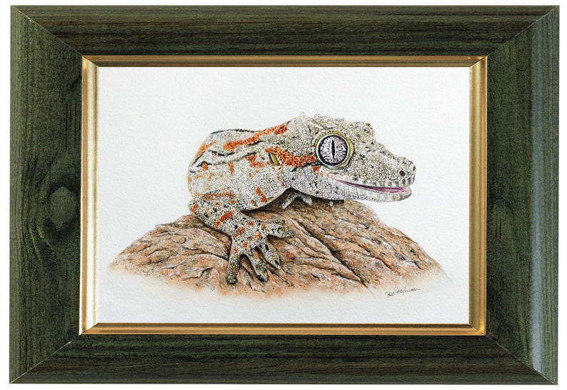 The gecko painting shown in a green frame with a gold internal border.