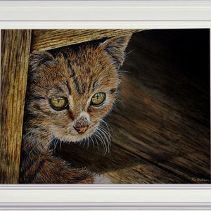 The finished cat painting in a white frame.
