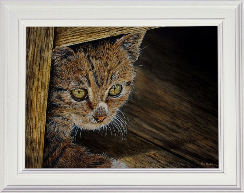 The finished cat painting in a white frame.