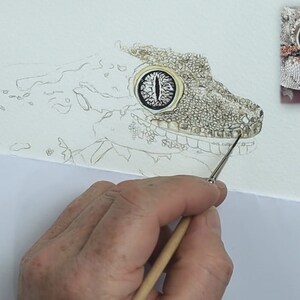 One of the early stages of this painting as Paul works on the initial layer of detail on the gecko's face.