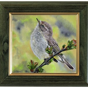 The bird painting in a dark green frame with a gold inner trim.